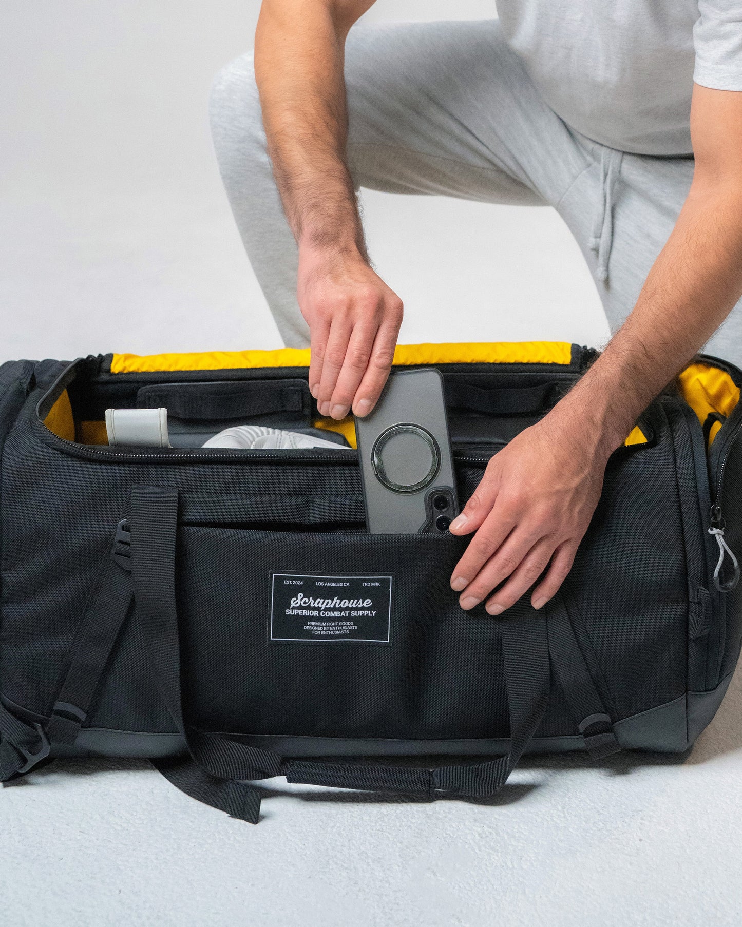 Sliding a phone into the quick-access front zip pocket on the Scuffle Duffle
