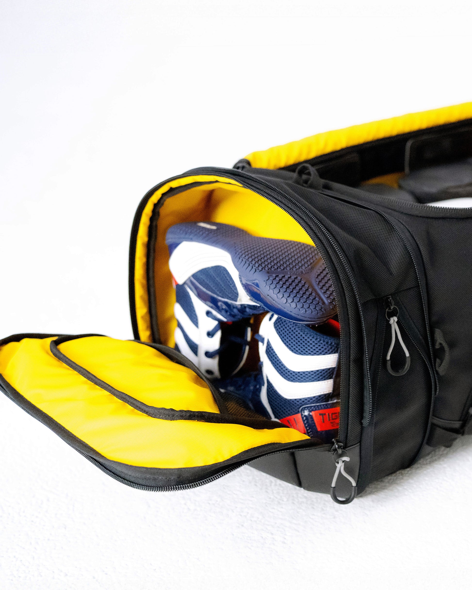 Expanding shoe compartment on the end of the Scuffle Duffle holding a pair of training shoes